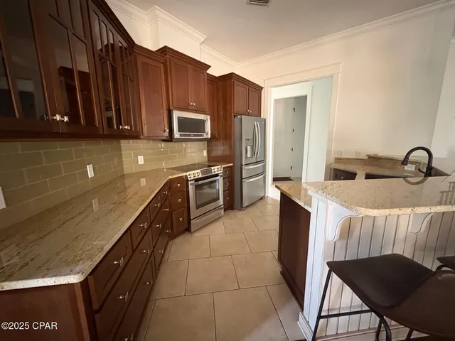 a kitchen with stainless steel appliances granite countertop a sink stove and cabinets