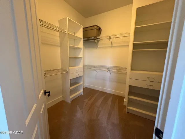 a view of walk in closet with empty racks