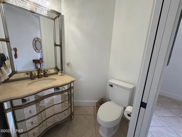 a bathroom with a granite countertop toilet sink and mirror
