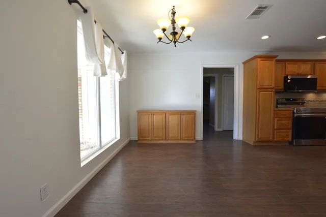 a kitchen with stainless steel appliances granite countertop a refrigerator a sink dishwasher a stove with wooden cabinets and floor