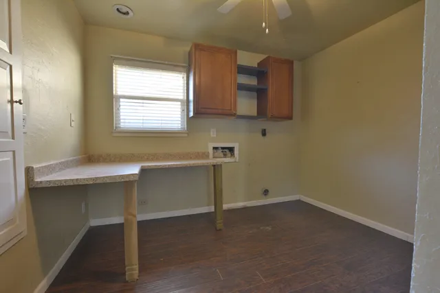 an empty room with cabinet and a ceiling fan