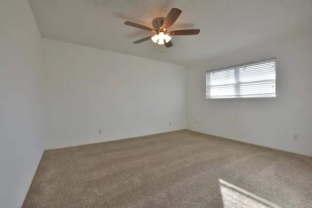 a view of an empty room with a ceiling fan