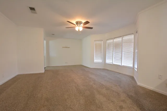 an empty room with a window and a fan