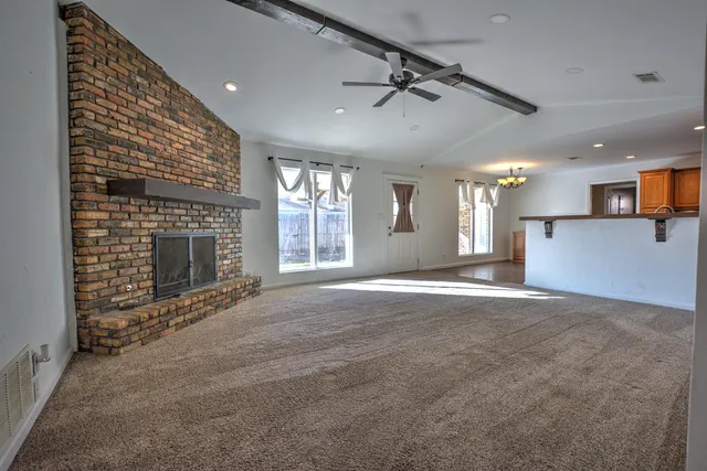 a view of empty room with a kitchen