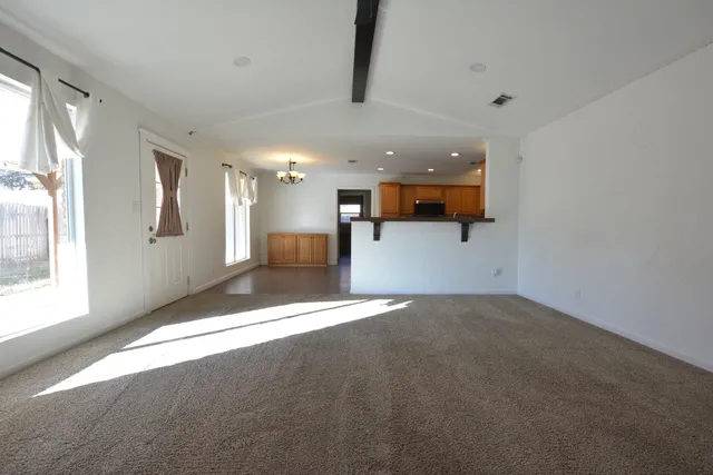 a view of an empty room with window and fireplace