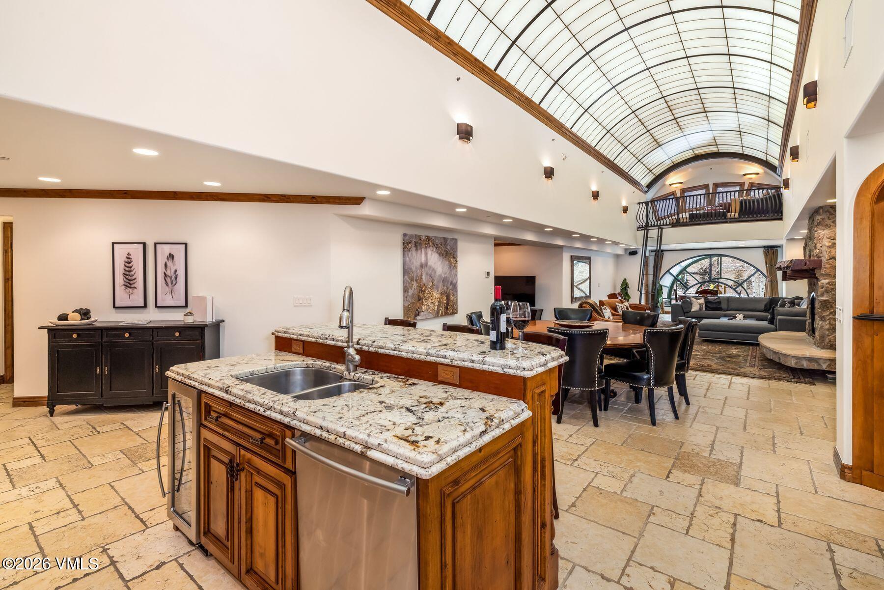 12 Vail Road, Unit R8 Vail, CO 81657 - Photo 22 of 41 a living room with stainless steel appliances kitchen island granite countertop a table chairs in it and a large window