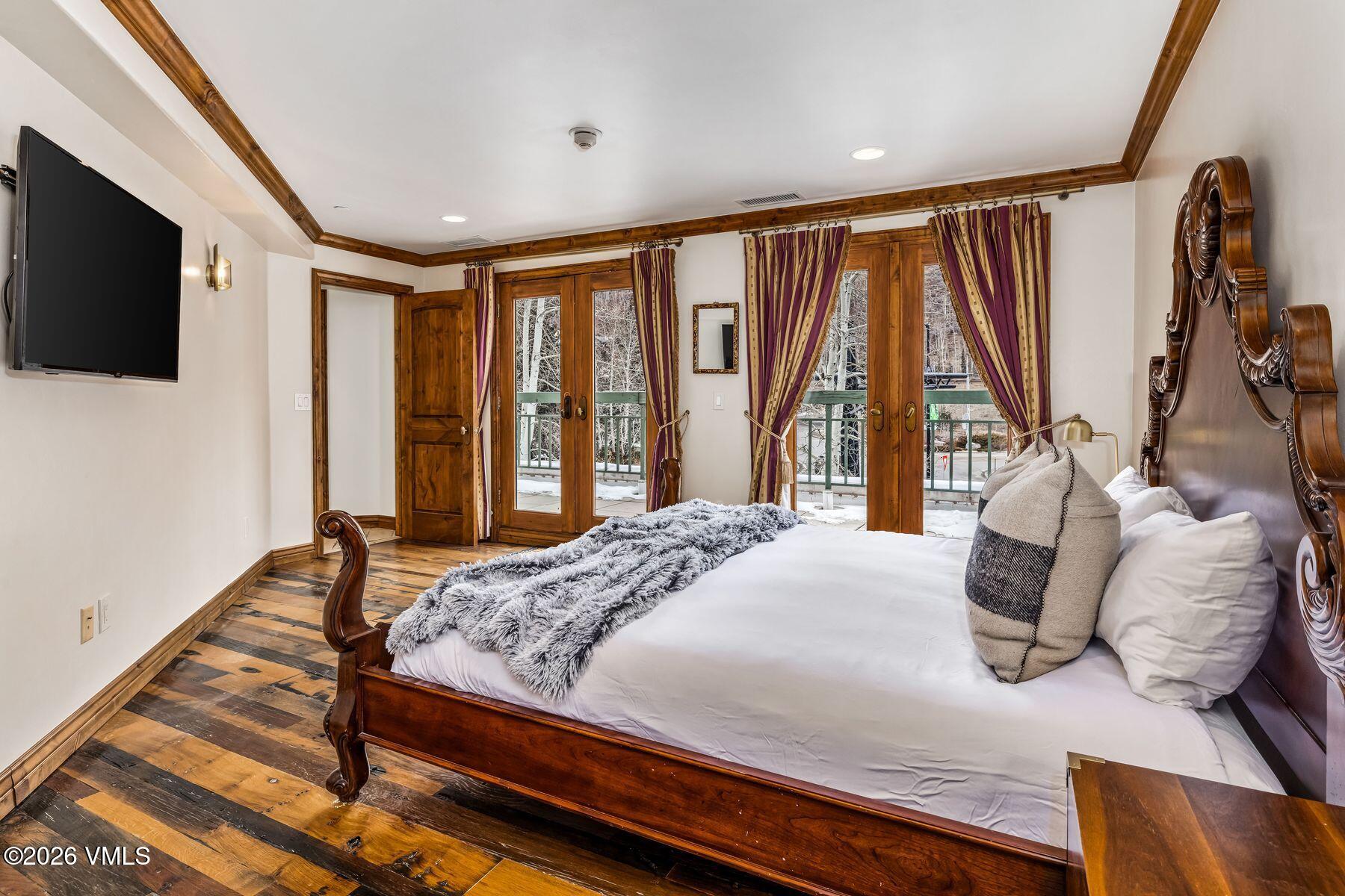 12 Vail Road, Unit R8 Vail, CO 81657 - Photo 34 of 41 a bedroom with a large bed and a flat tv screen on dresser