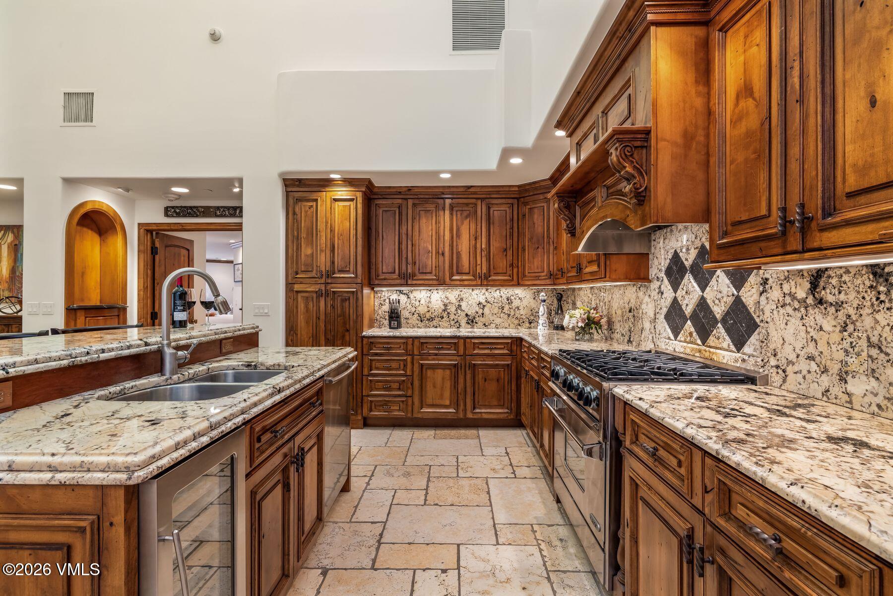 12 Vail Road, Unit R8 Vail, CO 81657 - Photo 5 of 41 a kitchen with stainless steel appliances granite countertop a sink stove and cabinets