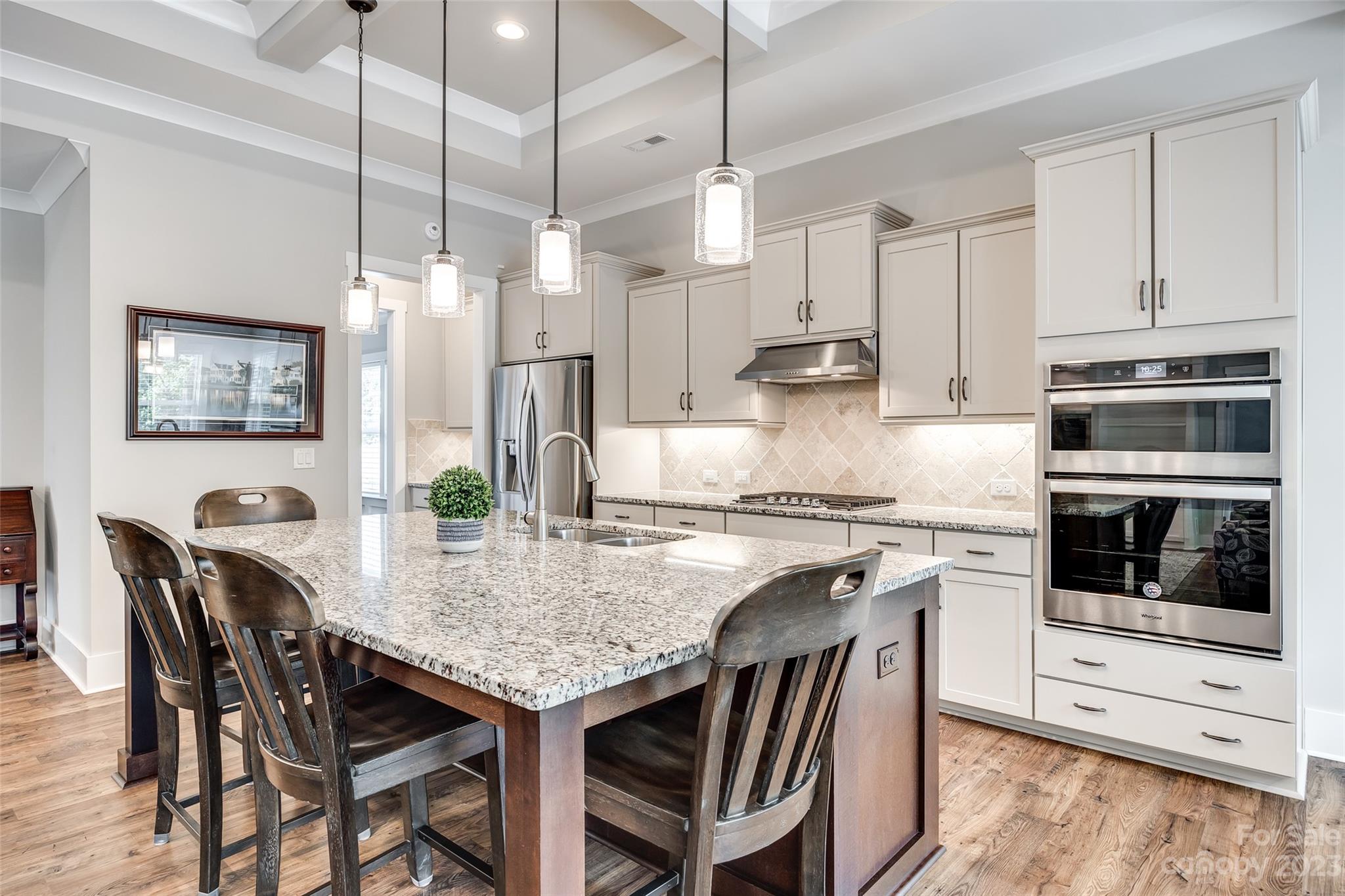 5284 Admirals Landing Lancaster, SC 29720 - Photo 13 of 48 a kitchen with stainless steel appliances granite countertop a stove a refrigerator a oven a white table and chairs with wooden floor