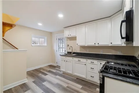 a kitchen with granite countertop a sink and a stove top oven