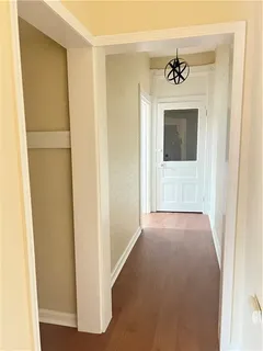 an empty room with wooden floor chandelier fan and windows