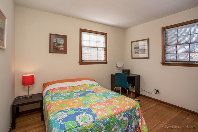 1016 Stoddard Avenue Wheaton, IL 60187 - Photo 8 of 14 a bedroom with a bed and a lamp on dresser