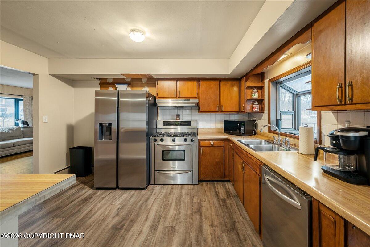 159 Summit Avenue Pocono Summit, PA 18346 - Photo 5 of 21 a kitchen with stainless steel appliances granite countertop a refrigerator a sink dishwasher a stove and white countertops with wooden floor