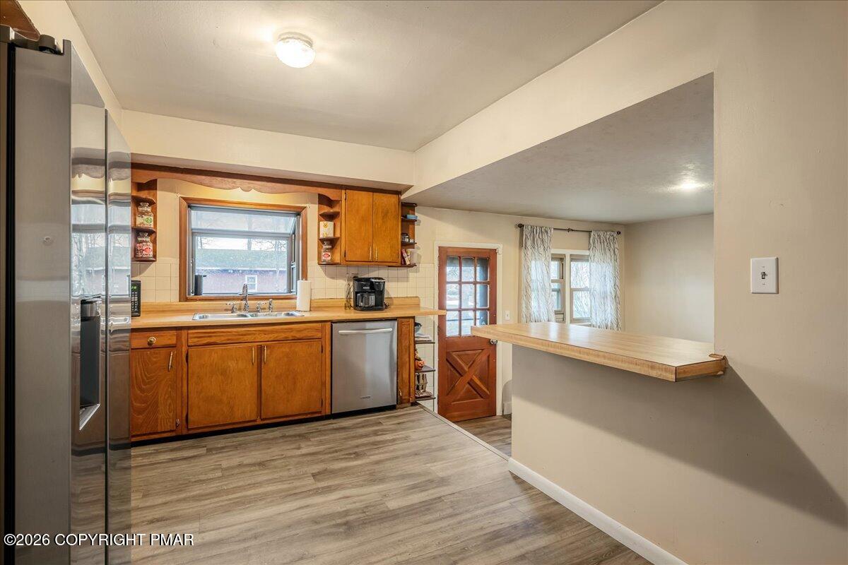 159 Summit Avenue Pocono Summit, PA 18346 - Photo 7 of 21 a kitchen with stainless steel appliances kitchen island granite countertop a stove a sink dishwasher and a refrigerator with wooden floor