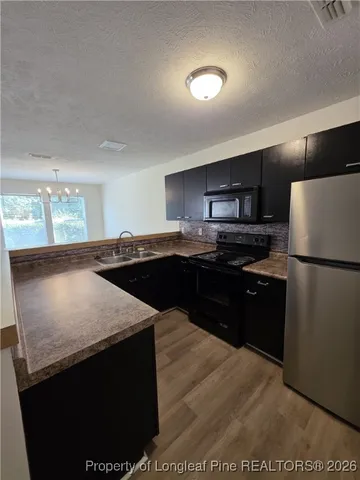 a kitchen with a sink a stove a refrigerator and a microwave