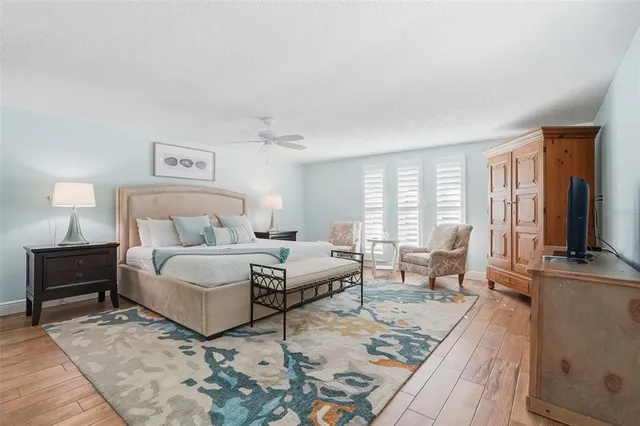 a spacious bedroom with a bed a couch and large windows