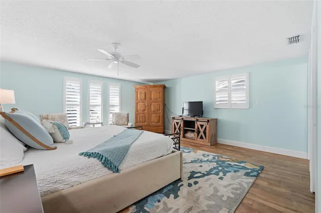 a bedroom with a bed and a table in it with window