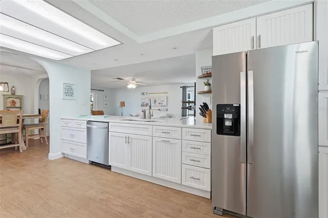 a kitchen with white cabinets and refrigerator