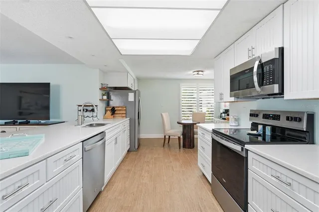 a large kitchen with stainless steel appliances granite countertop lots of counter space a sink and a window