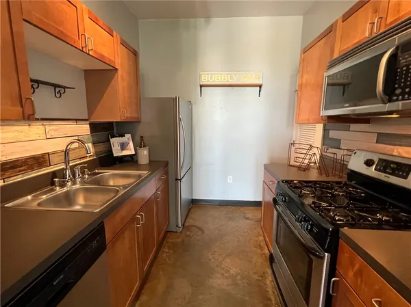 a kitchen with stainless steel appliances granite countertop a sink stove and refrigerator