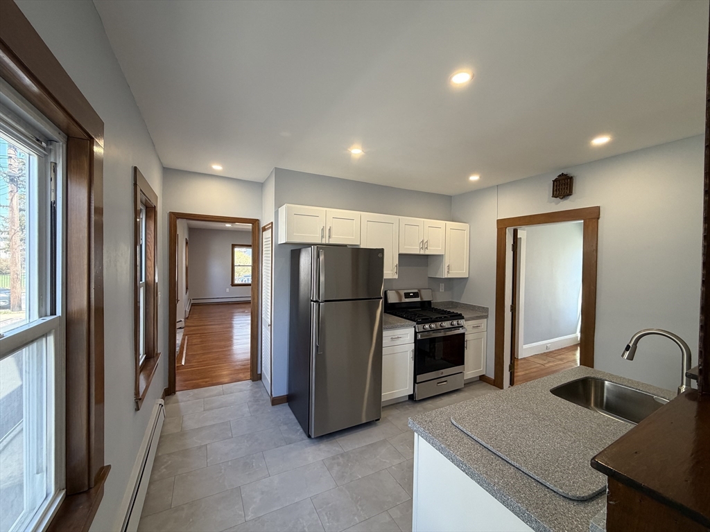 117 Merrymount Road, Unit 1 Quincy, MA 02169 - Photo 3 of 12 a kitchen with refrigerator and stove