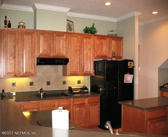 376 North Lombardy Loop Jacksonville, FL 32259 - Photo 8 of 24 a kitchen with granite countertop a refrigerator and a stove top oven