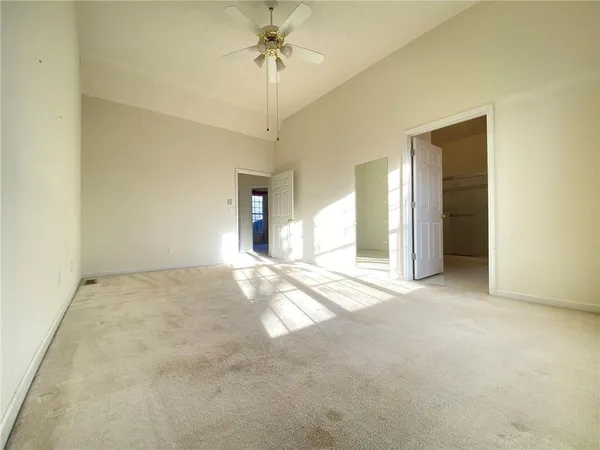 an empty room with a ceiling fan and a window