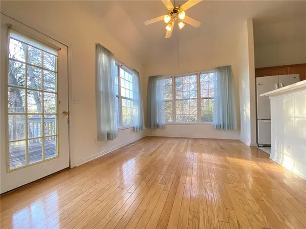 a view of an empty room with a window and wooden floor