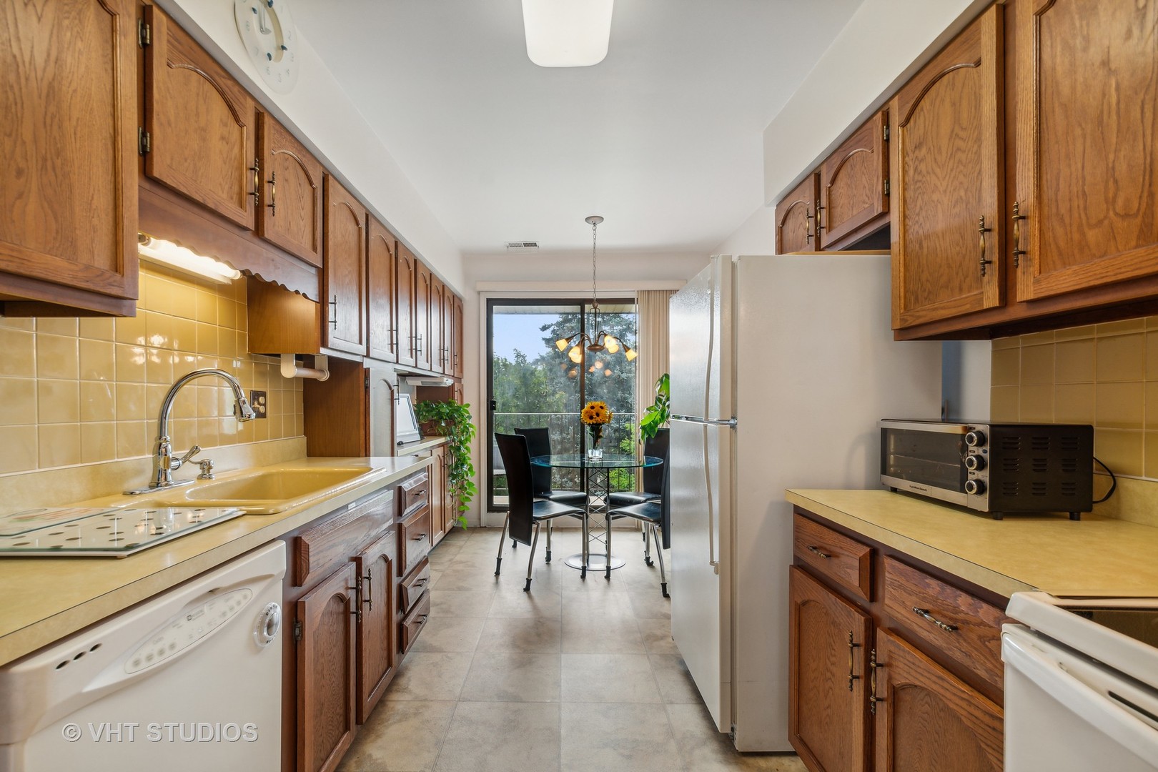 9801 Gross Point Road, Unit 308 Skokie, IL 60076 - Photo 7 of 16 a kitchen with a sink refrigerator and cabinets