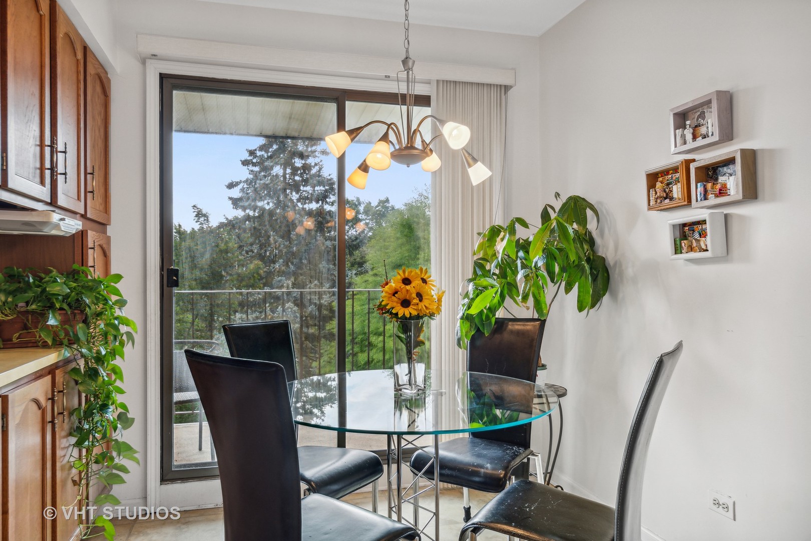 9801 Gross Point Road, Unit 308 Skokie, IL 60076 - Photo 8 of 16 a vase of flowers sitting on a table with chair and a potted plant