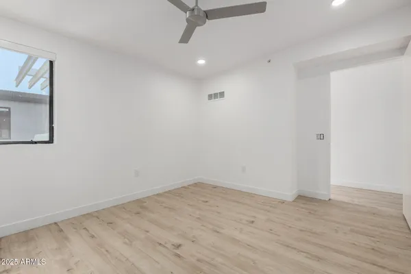a view of a room with wooden floor and ceiling fan