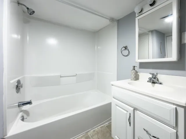 a white bath tub sitting next to a bathroom sink