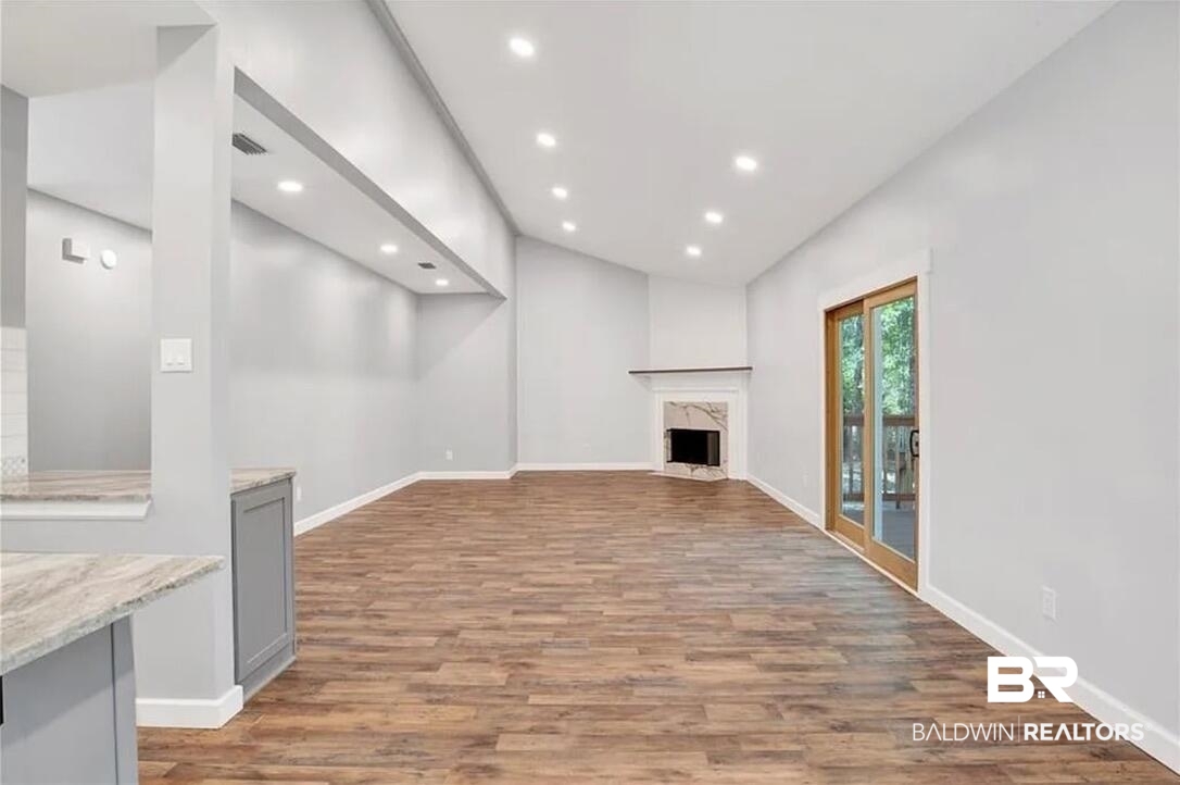 632 Ridgewood Drive Daphne, AL 36526 - Photo 21 of 36 Unfurnished living room with hardwood / wood-style floors and a fireplace