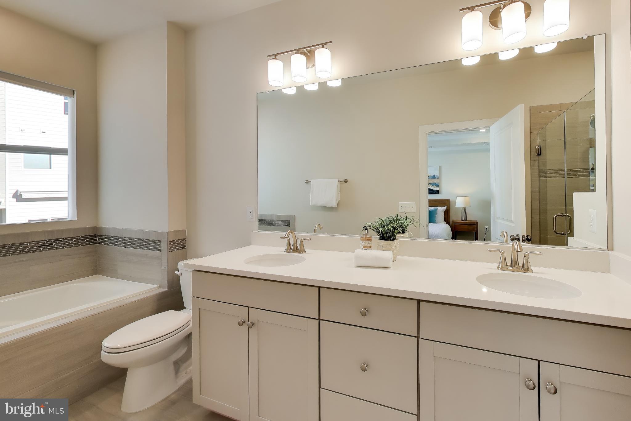 111 Armstrong Place Gaithersburg, MD 20878 - Photo 17 of 50 a bathroom with a sink a toilet a vanity a mirror a bathtub and vanity
