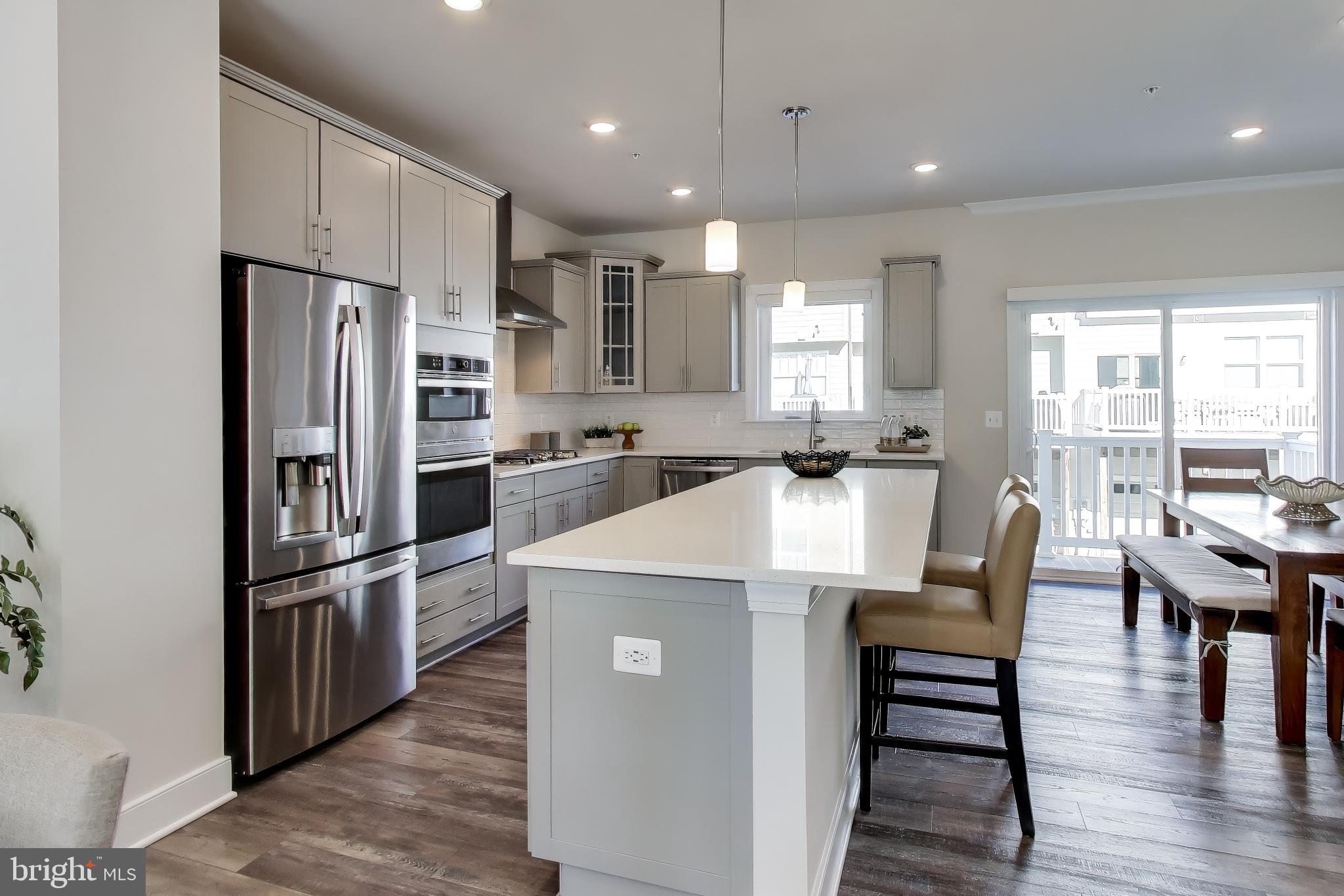 111 Armstrong Place Gaithersburg, MD 20878 - Photo 10 of 50 a kitchen with refrigerator cabinets dining table and chairs