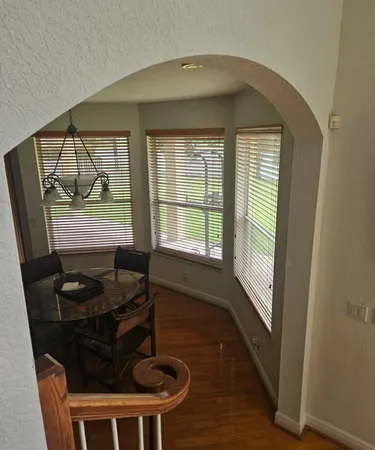 a view of a hallway with wooden floor and staircase