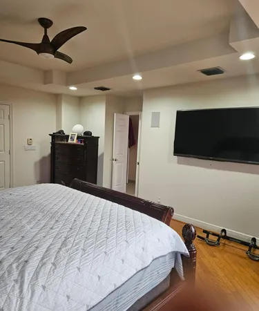 a bedroom with a bed and wooden floor