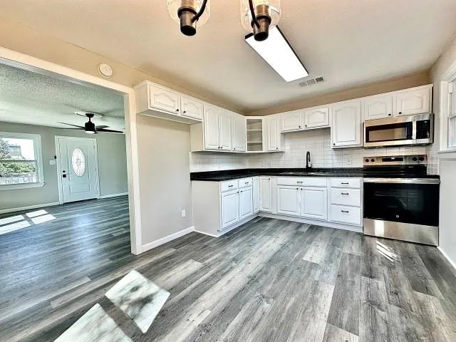 a large kitchen with cabinets and stainless steel appliances