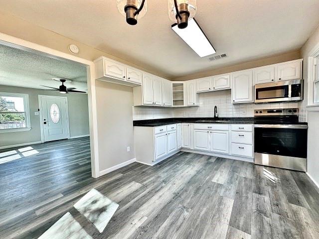 903 North 4th Street Ballinger, TX 76821 - Photo 9 of 12 a large kitchen with cabinets and stainless steel appliances