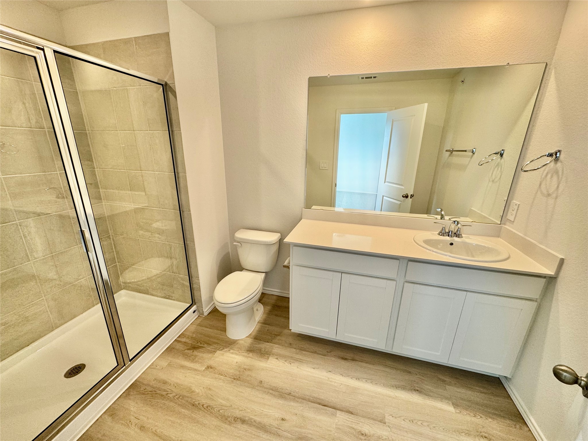 104 Calcite Road, Unit 3 Kyle, TX 78640 - Photo 3 of 7 Full bathroom featuring vanity, a shower stall, and light wood-type flooring