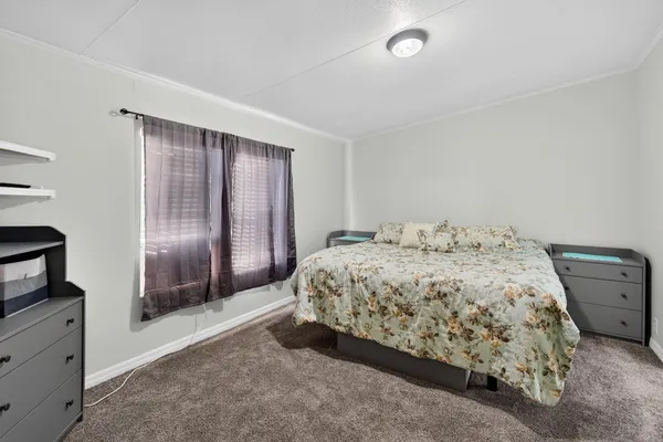 a spacious bedroom with a bed and a flat screen tv