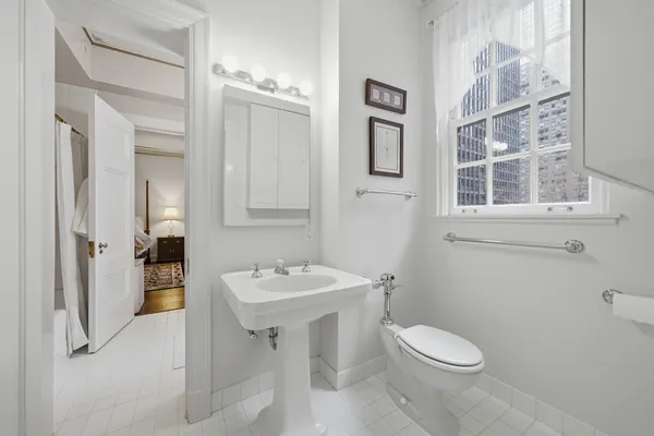 a bathroom with a toilet sink and mirror