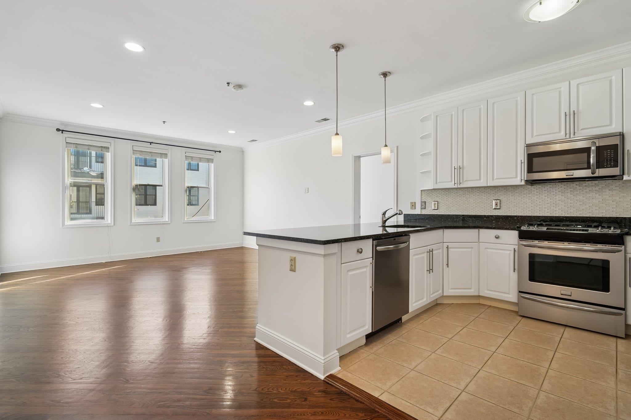 a kitchen with stainless steel appliances granite countertop a stove a sink and a microwave