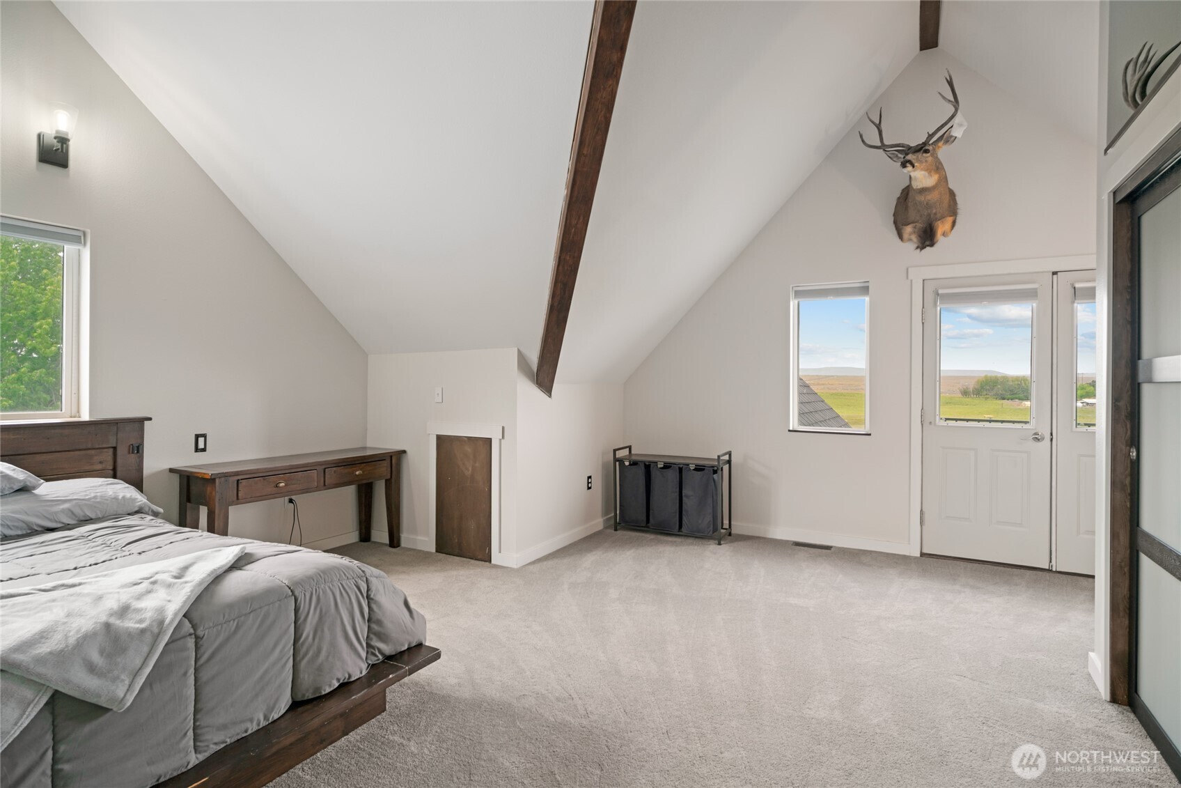 11975 Northeast Neppel Road Moses Lake, WA 98837 - Photo 24 of 33 a spacious bedroom with a bed and a chandelier