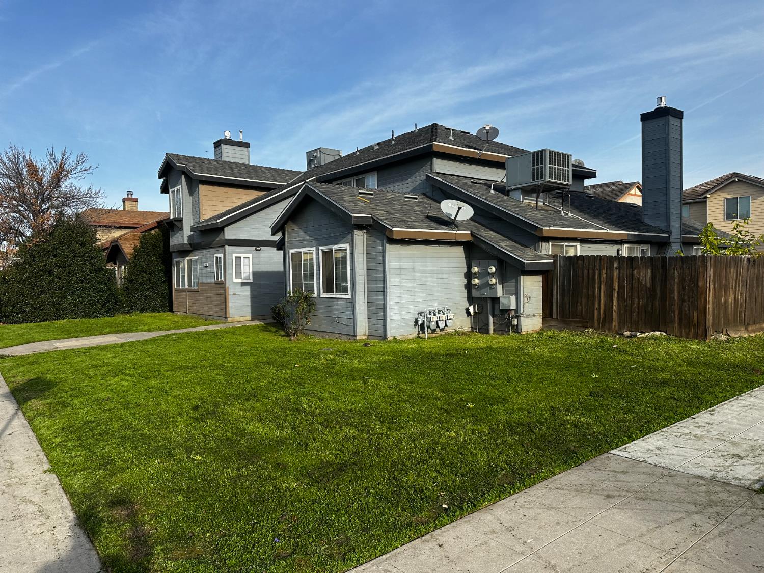 4270 West Regency Avenue Fresno, CA 93722 - Photo 4 of 6 a front view of a house with a yard and many windows