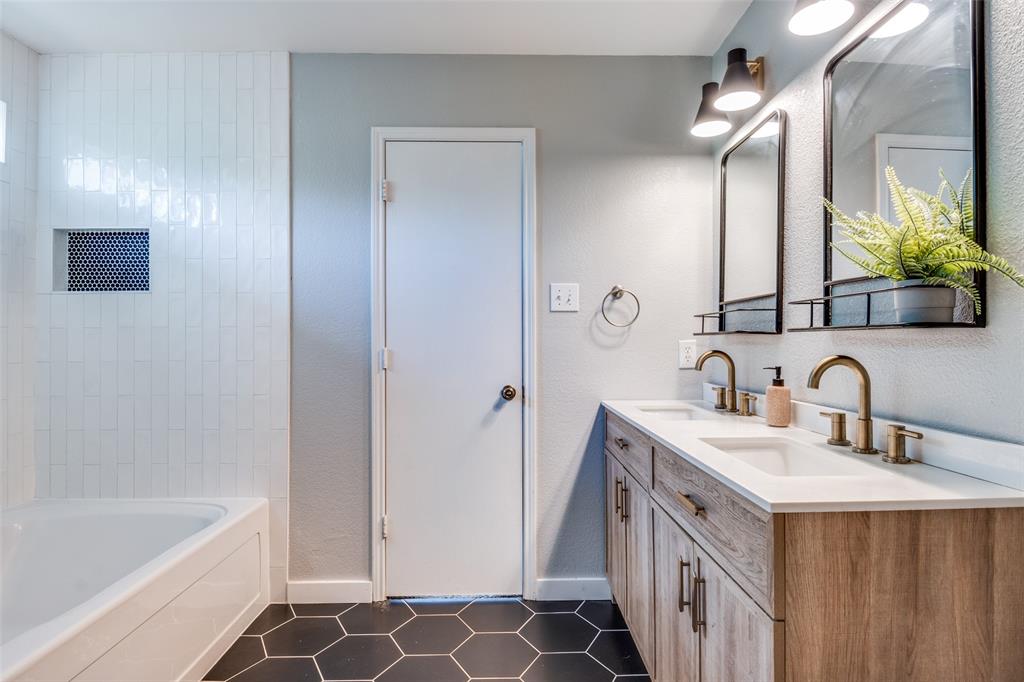 4018 Cedar Elm Lane Dallas, TX 75212 - Photo 14 of 22 a bathroom with a double vanity sink a mirror a bathtub and shower