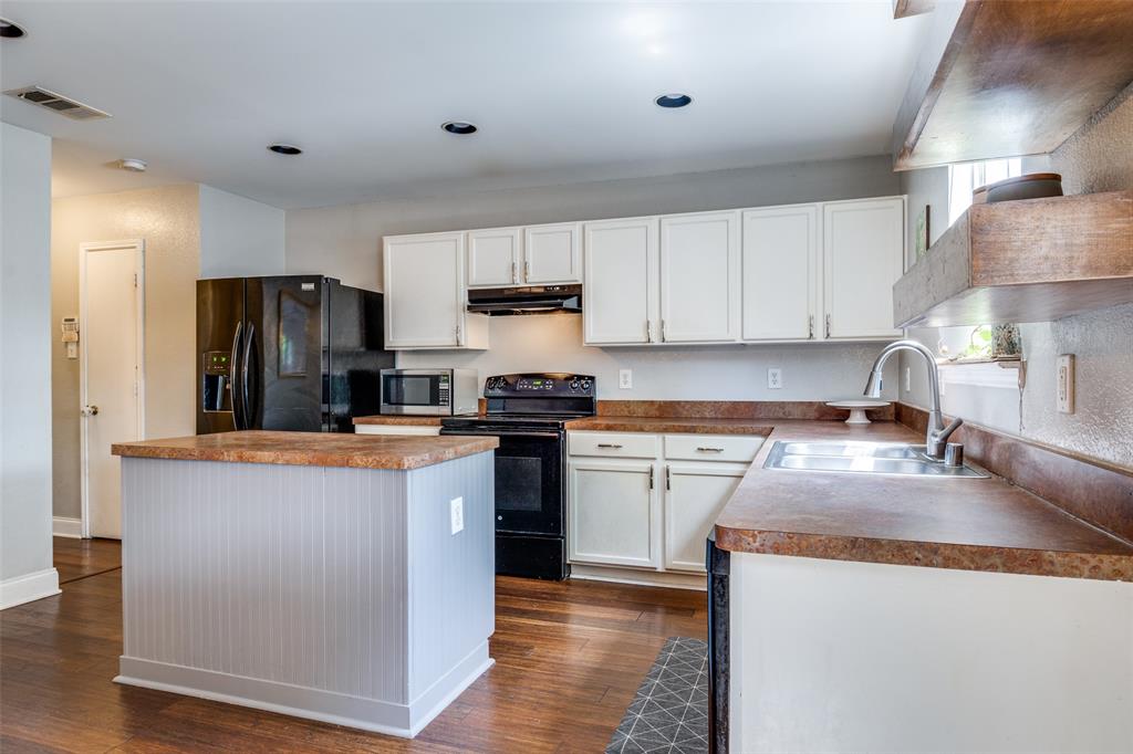 4018 Cedar Elm Lane Dallas, TX 75212 - Photo 7 of 22 a kitchen with granite countertop wooden cabinets a refrigerator a stove a sink and dishwasher with wooden floor
