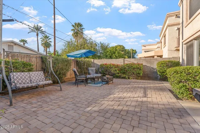 a view of a patio with a table and chairs under an umbrella