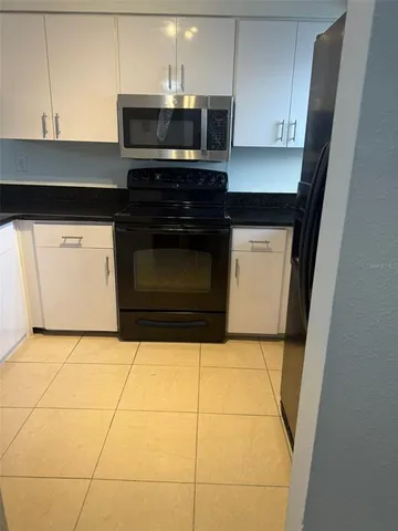 a kitchen with granite countertop a stove a microwave and a sink