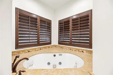 a bathroom with a bathtub and next to a window